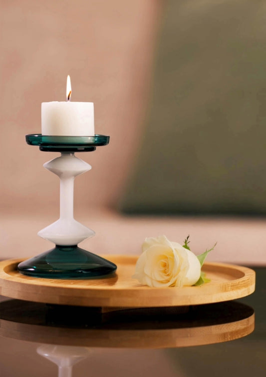 Tall emerald glass candle stand with white pillar candle for elegant home decor.